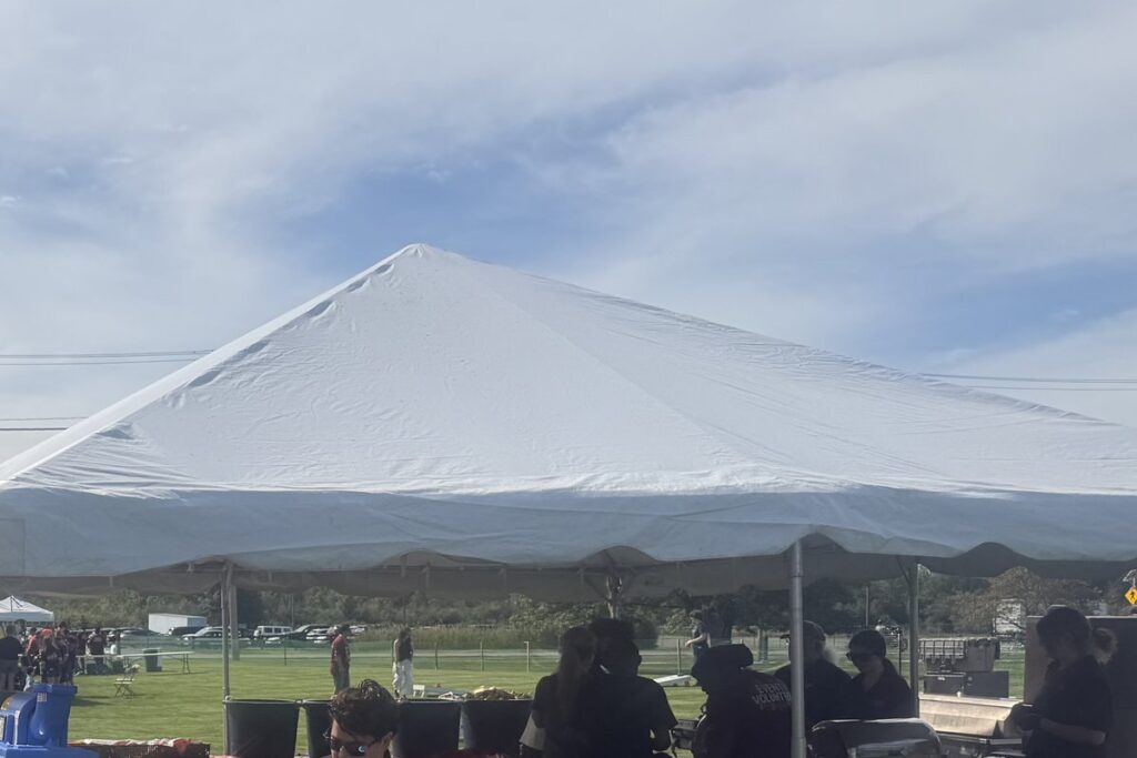 White frame tent with fall tablecloths at a Halloween season party