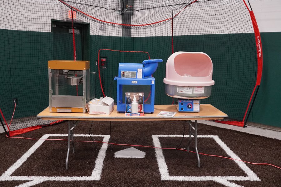 Popcorn machine, snow cone machine and cotton candy machine lined up on a rental table for a party