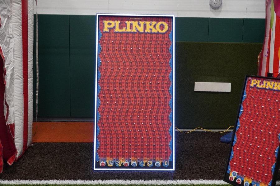 Glowing LED Plinko game board set up in a school gym for a holiday event, Just In Case Party Rentals